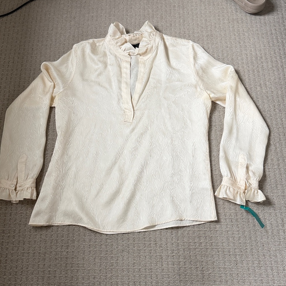 Nili Lotan cream silk ruffled blouse.